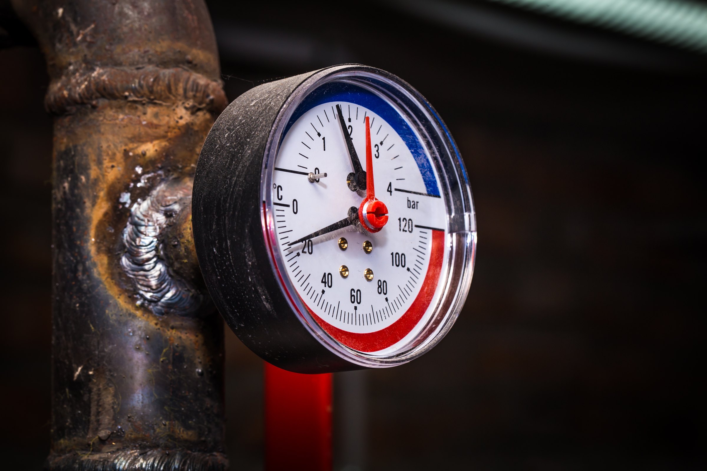 Pressure gauge mounted on a worn, welded steel pipe