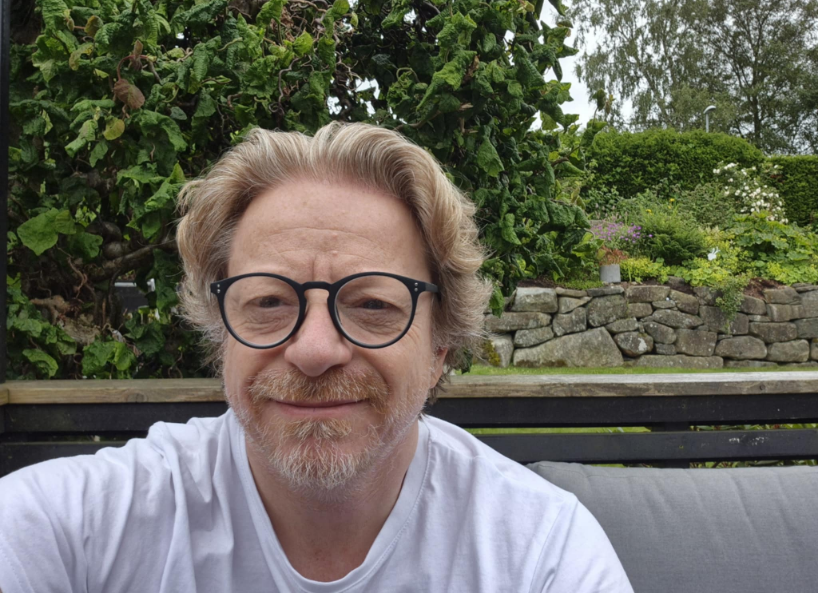 Øystein Bruncell Larsen, smiling, outdoors in a garden
