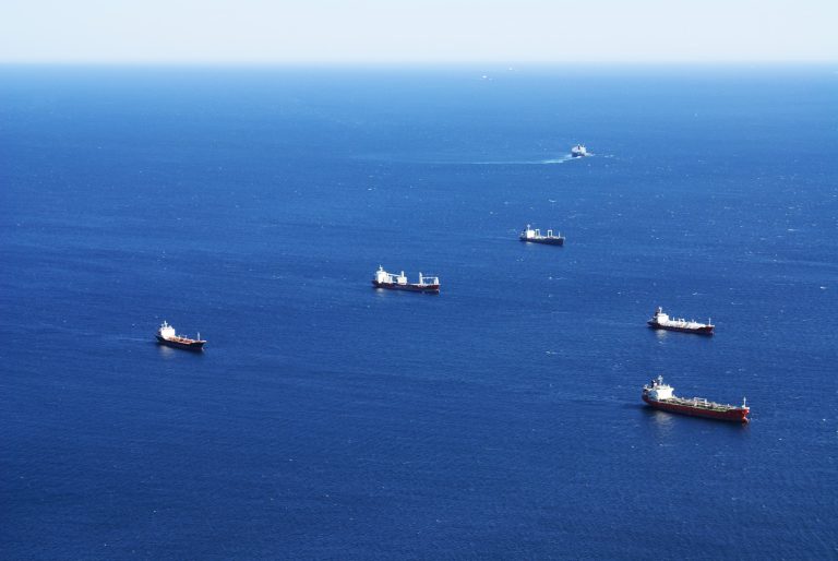 Several ships spread across deep blue open sea, seen from high above